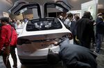 An attendee views the Tesla Motors Inc. Model X vehicle with Panasonic Corp. battery during the 2015 Consumer Electronics Show (CES) in Las Vegas, Nevada, on Jan. 6, 2015.
