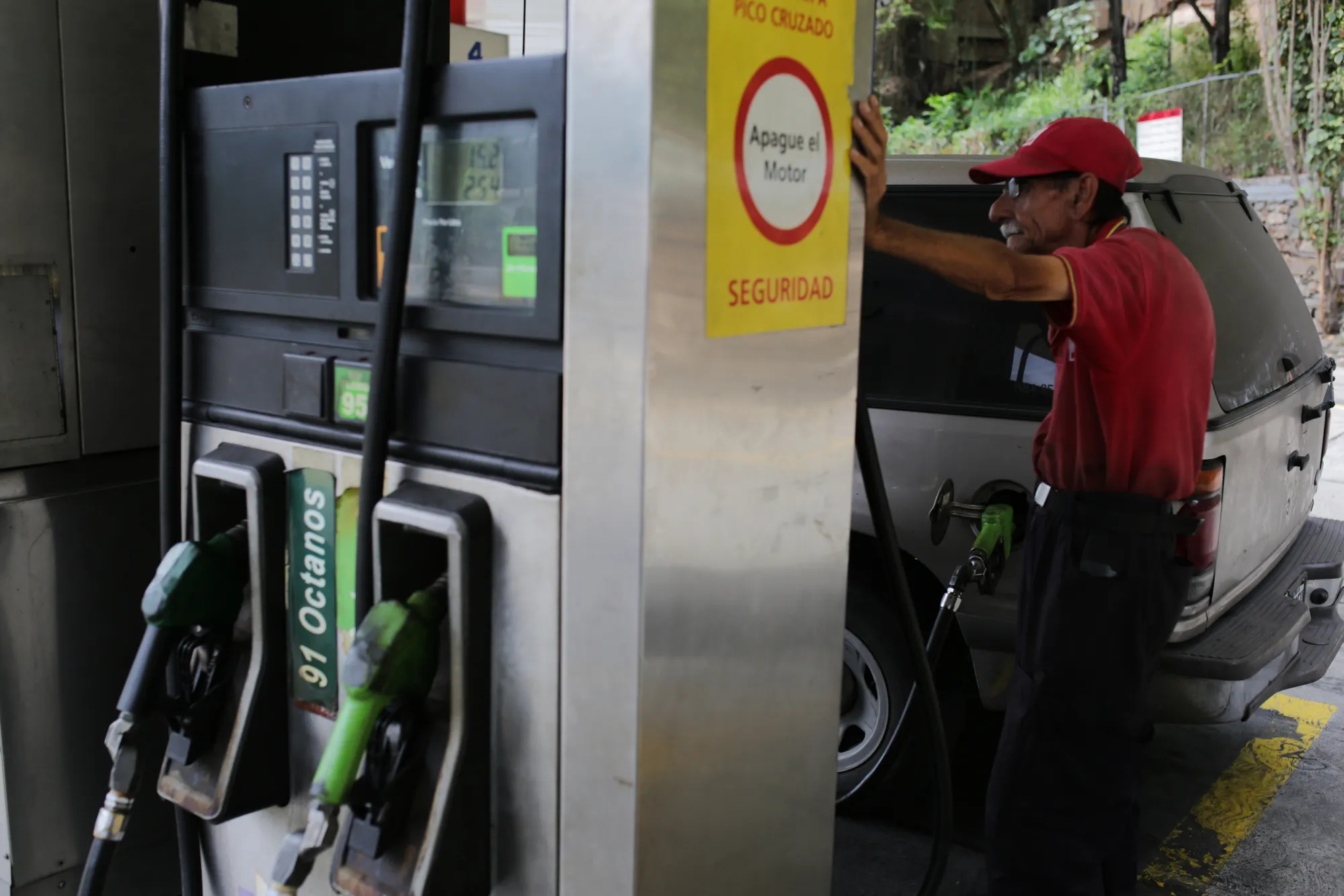 An employee fuels a vehicle at a Petroleos de Venezuela SA (PDVSA) gas station in Caracas, Venezuela, on Tuesday, May 22, 2018. The U.S. sanctions in response to Venezuela President Nicolas Maduro's contested re-election barely touch either the oil sector or country's crown jewel, oil company PDVSA.