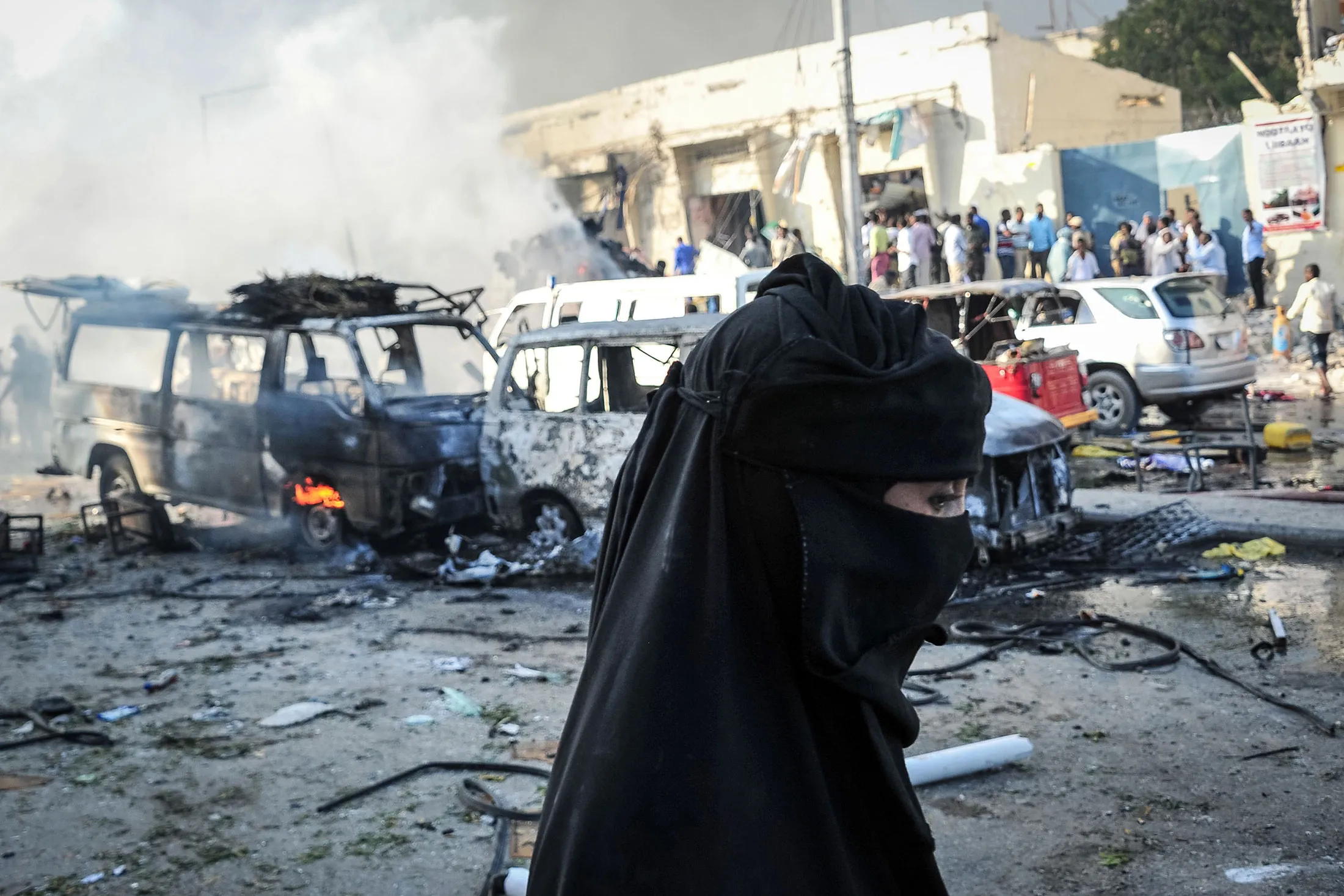 A woman walks by wreckages of vehicles following the explosion of a truck bomb in the centre of Mogadishu, on Oct. 14.
