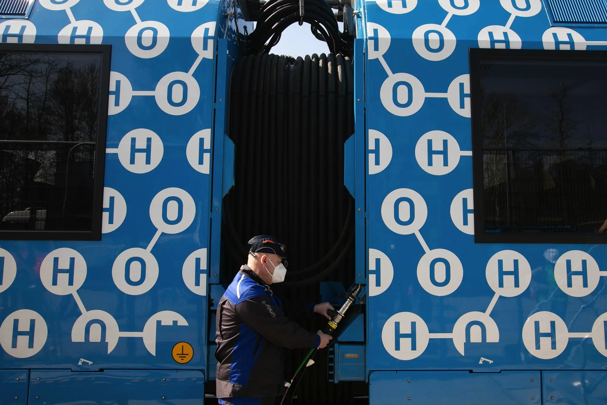 A worker refuels a hydrogen fuel cell powered prototype railway train.