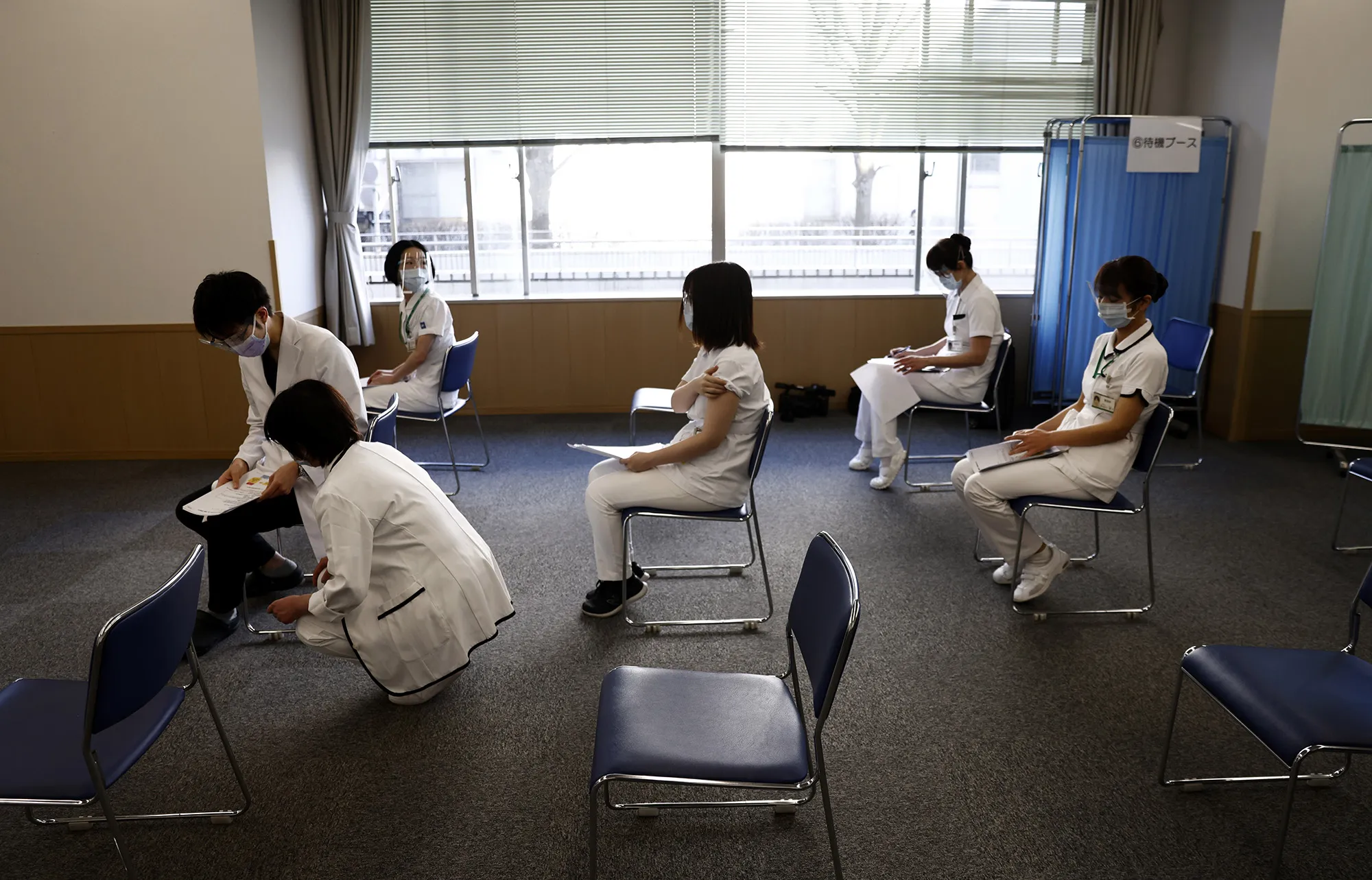 Medical workers wait for consultation after receiving a dose of the Pfizer-BioNTech Covid-19 vaccine at the Tokyo Medical Center in Tokyo.