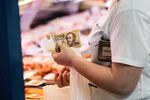 A customer pays using Hungarian forint banknotes at the Great Market Hall food market in Budapest.