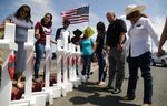 Volunteers pray over white handmade crosses memorializing the victims of a mass shooting which left at least 22 people dead on August 5, 2019 in El Paso, Texas.
