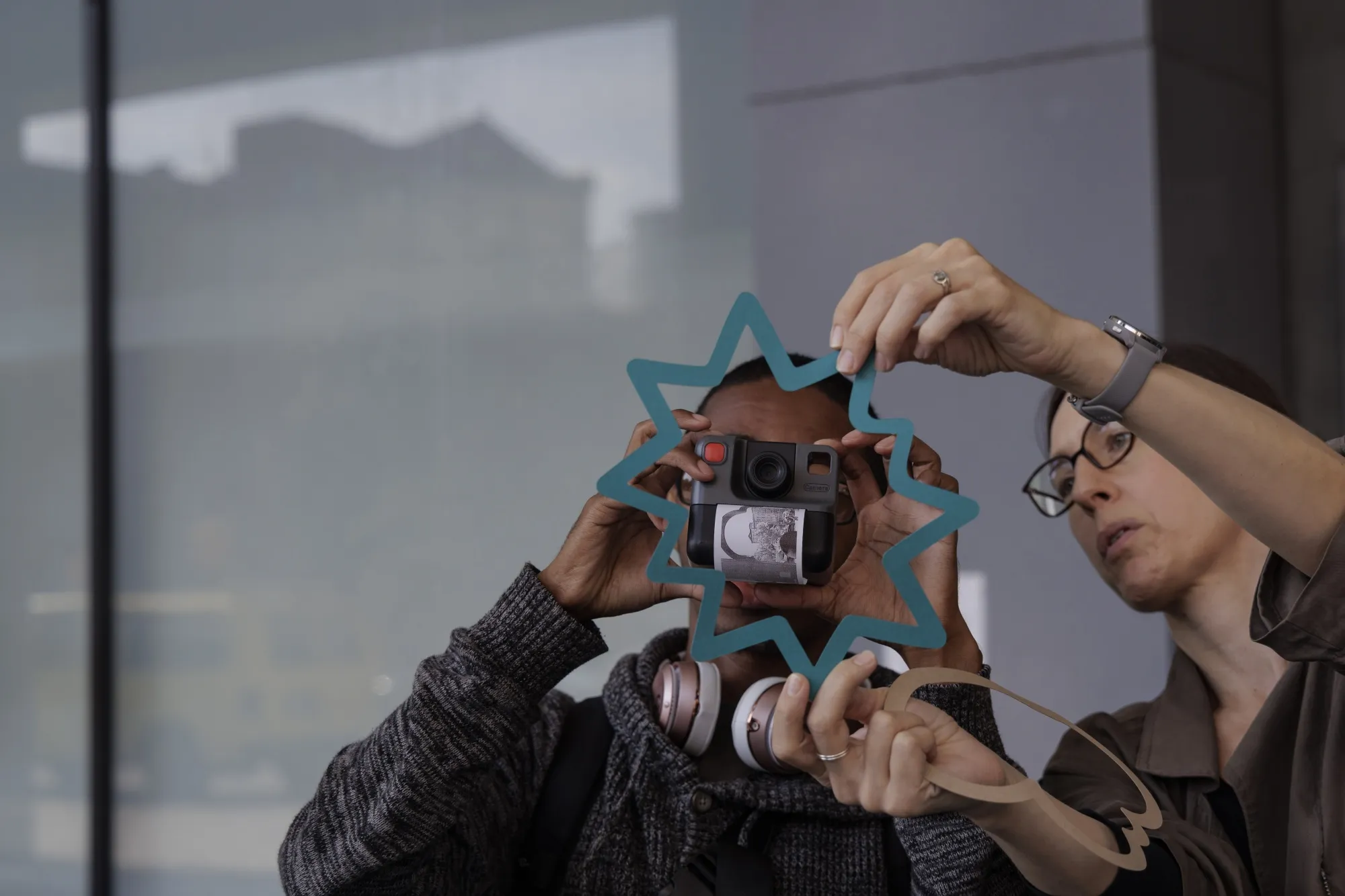 Bryony Roberts, an architect with WIP Collaborative, right, helps a participant use photography and objects to illustrate the experiences of navigating city spaces for a neurodiverse individual.&nbsp;