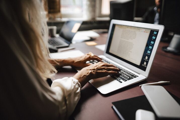 RF Midsection of female lawyer using laptop while typing at desk in office