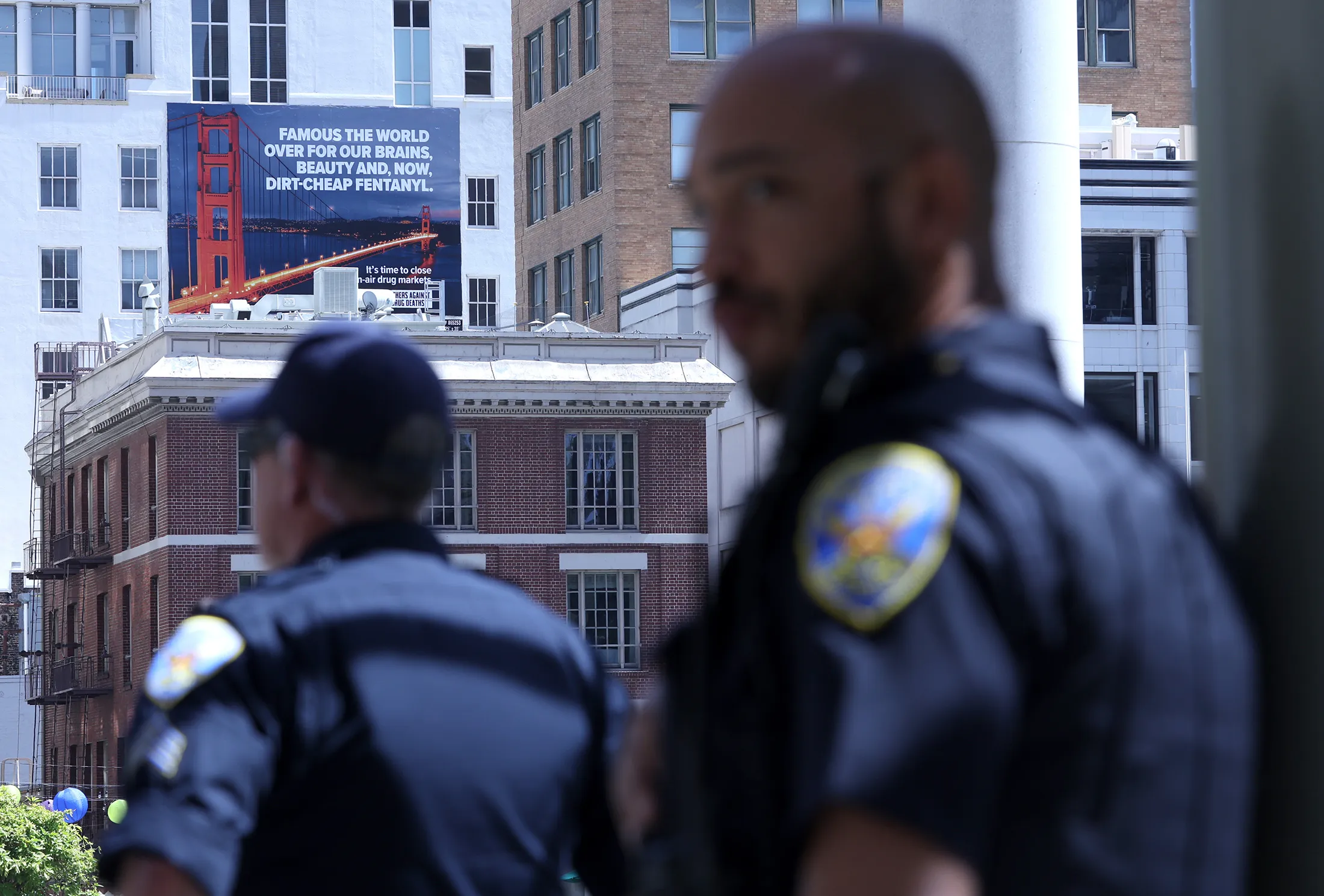 San Francisco police officers patrol near a new controversial billboard that warns against fentanyl in the city.