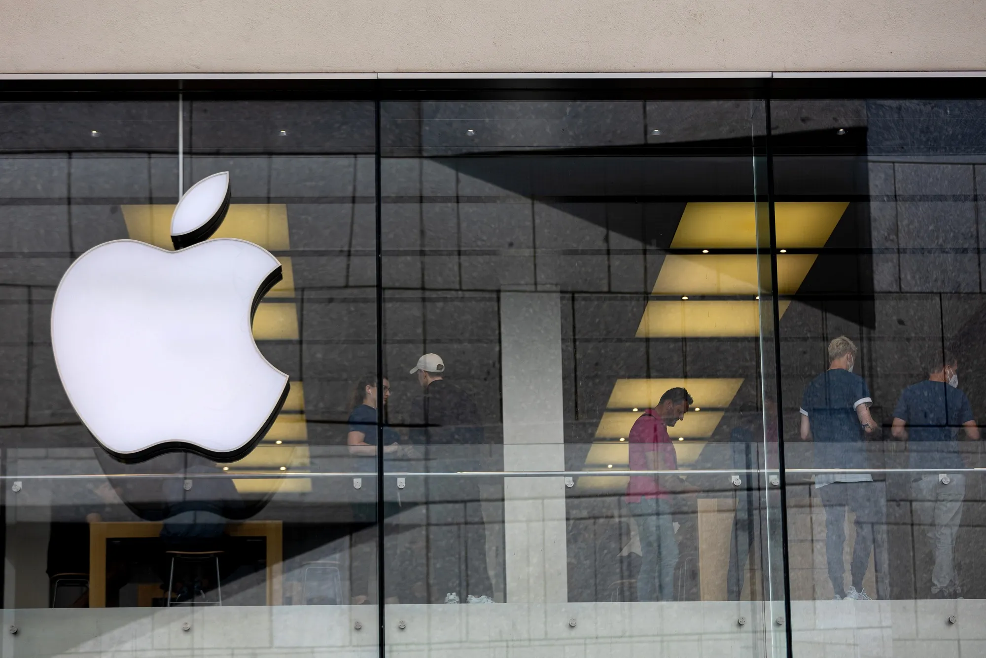 Employees assist customers at an Apple Inc. store in Munich, Germany.&nbsp;