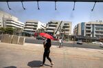 A woman walks&nbsp;underneath sprinklers releasing water vapor to relieve pedestrians amidst a heatwave in Dubai, United Arab Emirates.