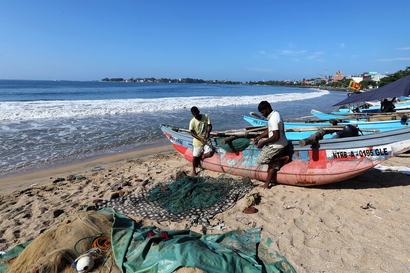 Fishermen prepare a net on a beach in Galle, Sri Lanka.