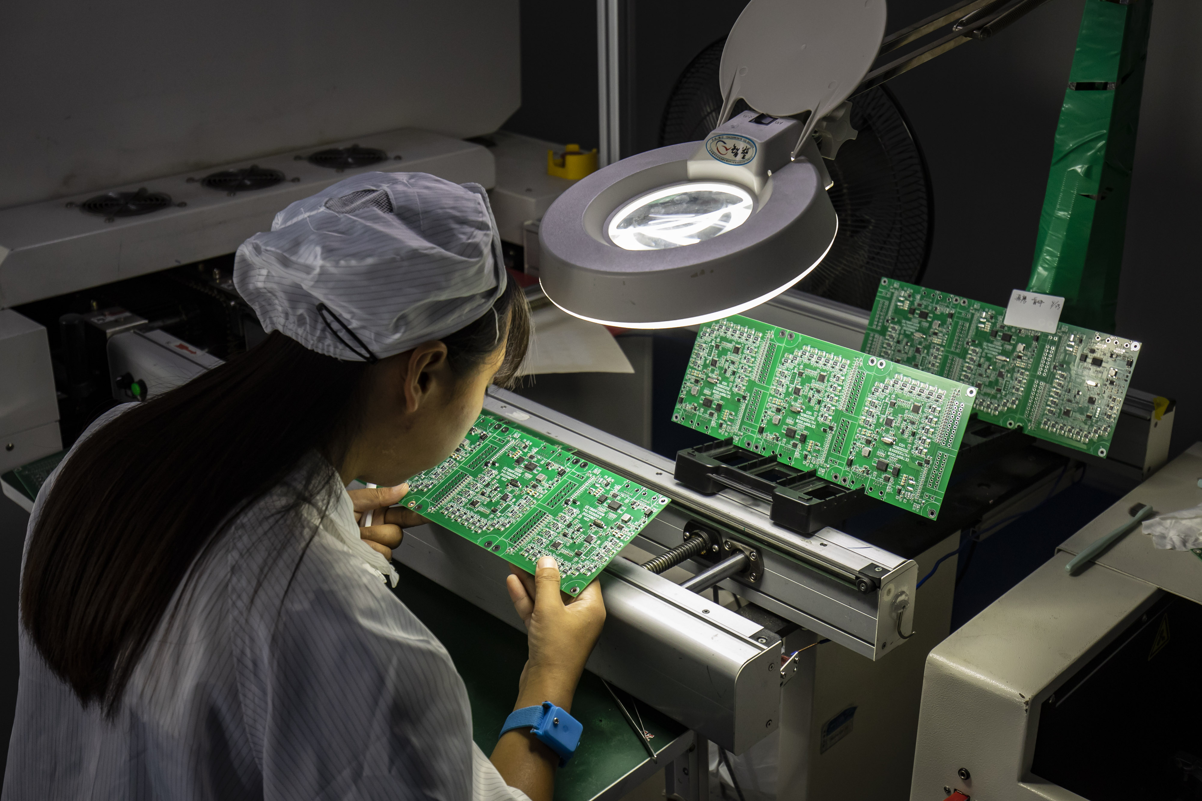 An employee inspects circuit boards at a factory in Suzhou, China.