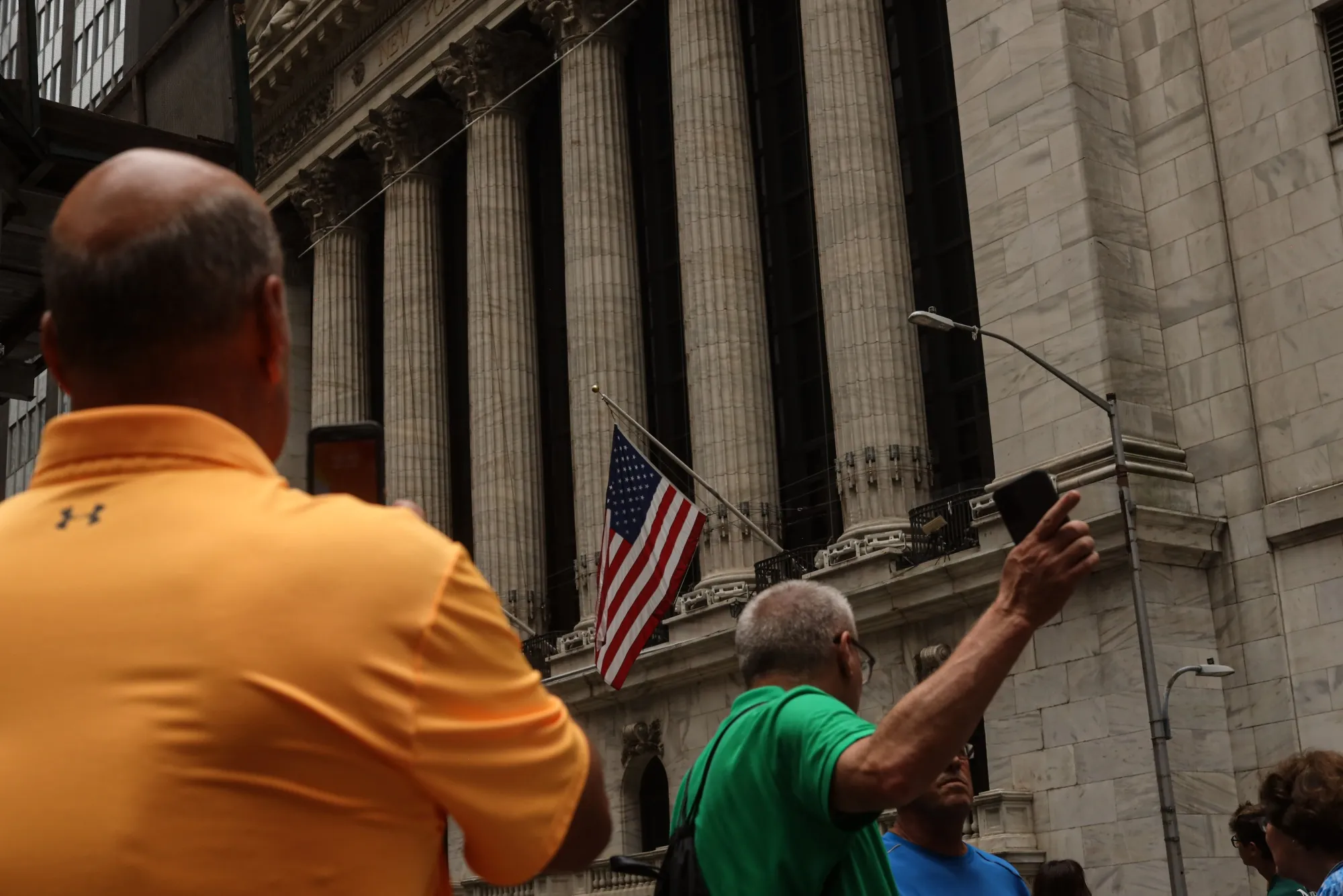 Pedestrians outside the New York Stock Exchange on Monday. The market is on edge over corporate earnings and the immediate outlook for the economy.