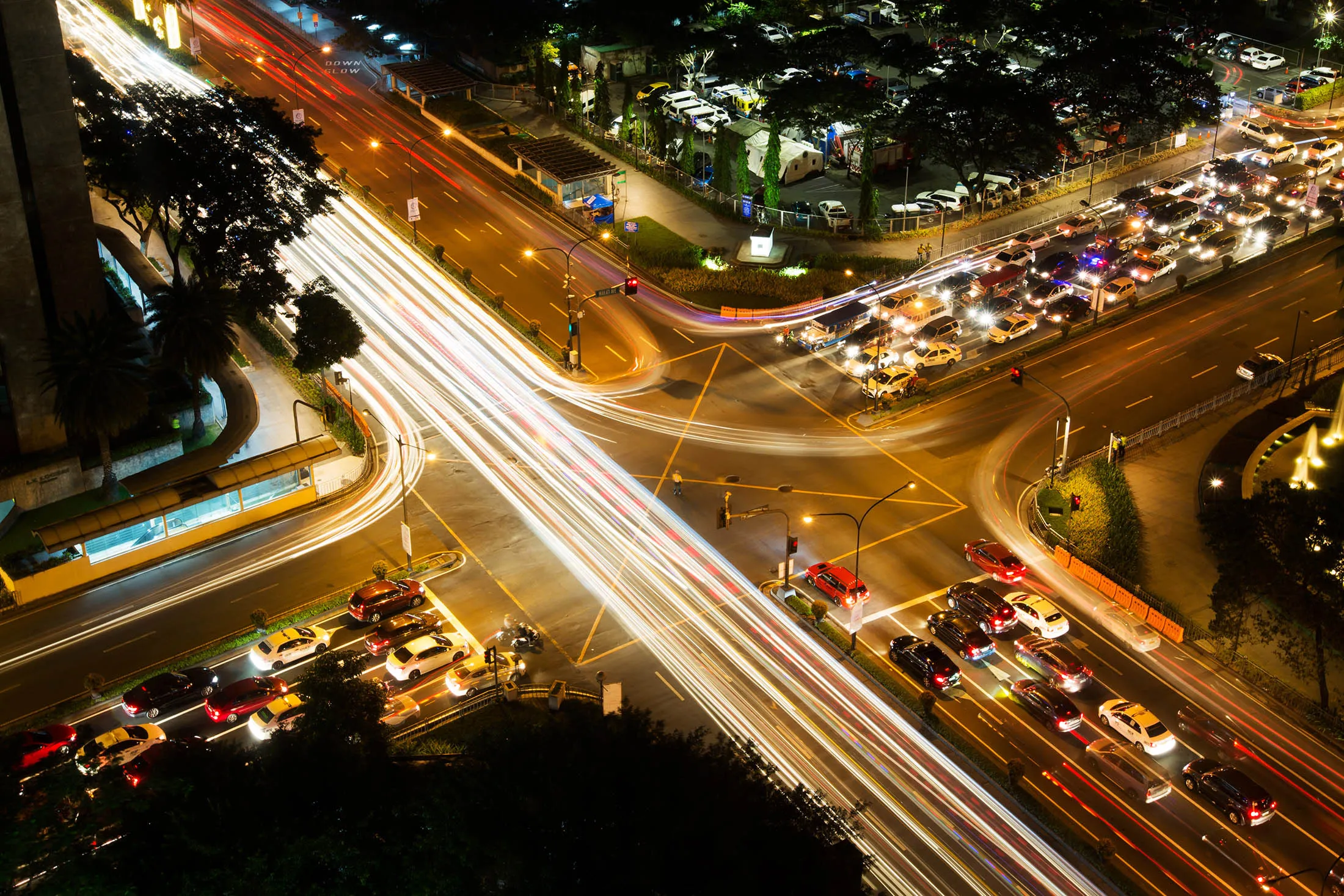 Light trails are left by moving traffic at a junction in this long exposure photograph taken at night in the Makati district of Manila, the Philippines, on Sunday, Nov. 15, 2015. Economic growth in Asia Pacific will likely accelerate to 3.4% in 2016 from 3.1% this year, Dennis Hew, APEC's policy support director, said at press briefing in Manila.
