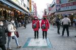 Tourist guides in masks stand in Namdaemun Market in Seoul, March 5.