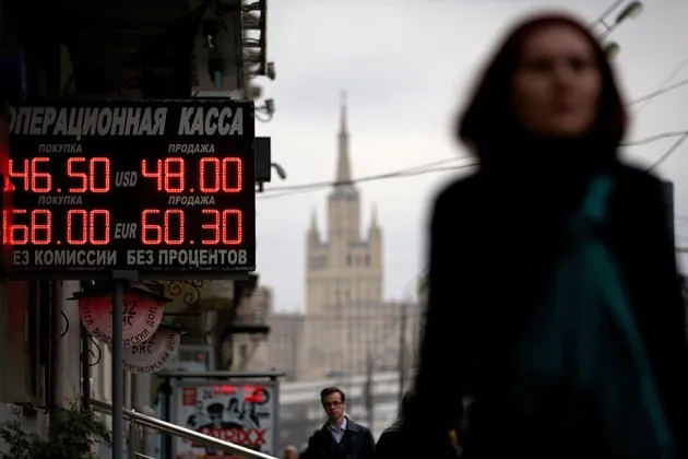 People walk past a display with exchange rates in downtown Moscow on Nov. 14