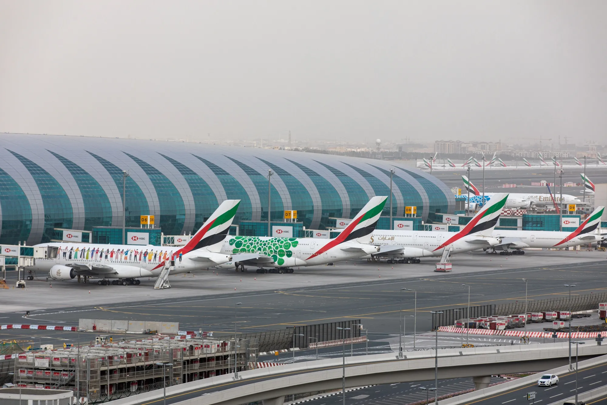 Passenger aircraft, operated by Emirates, stand beside the terminal building at Dubai International Airport in Dubai.