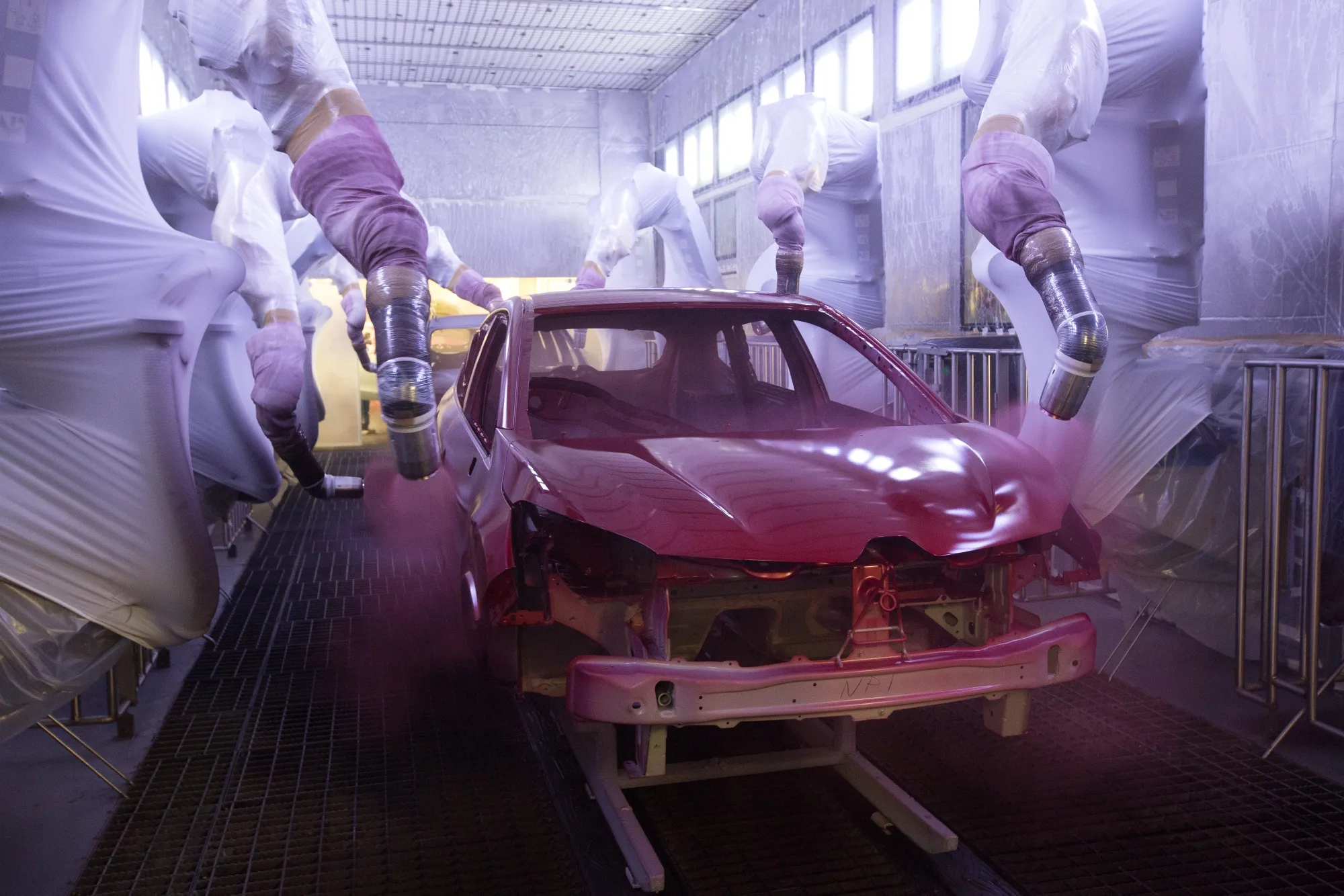 Robotic arms spray the body shell of a Renault Captur crossover sport utility vehicle inside the Renault automobile plant in Moscow.