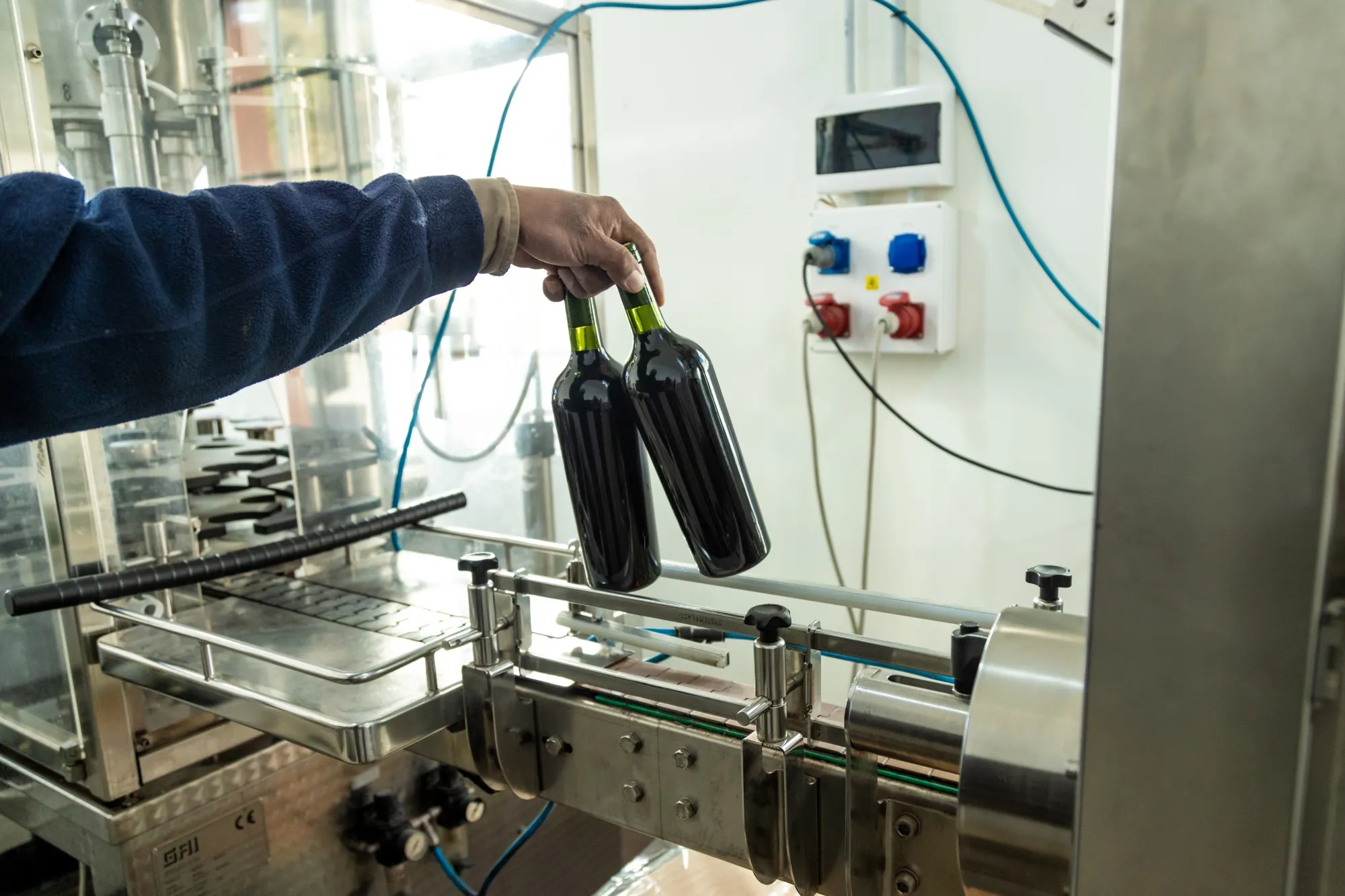 A worker holds unlabeled bottles of wine at the San Pedro de Yacochuya vineyard in Cafayate, Argentina, on&nbsp;July 9.