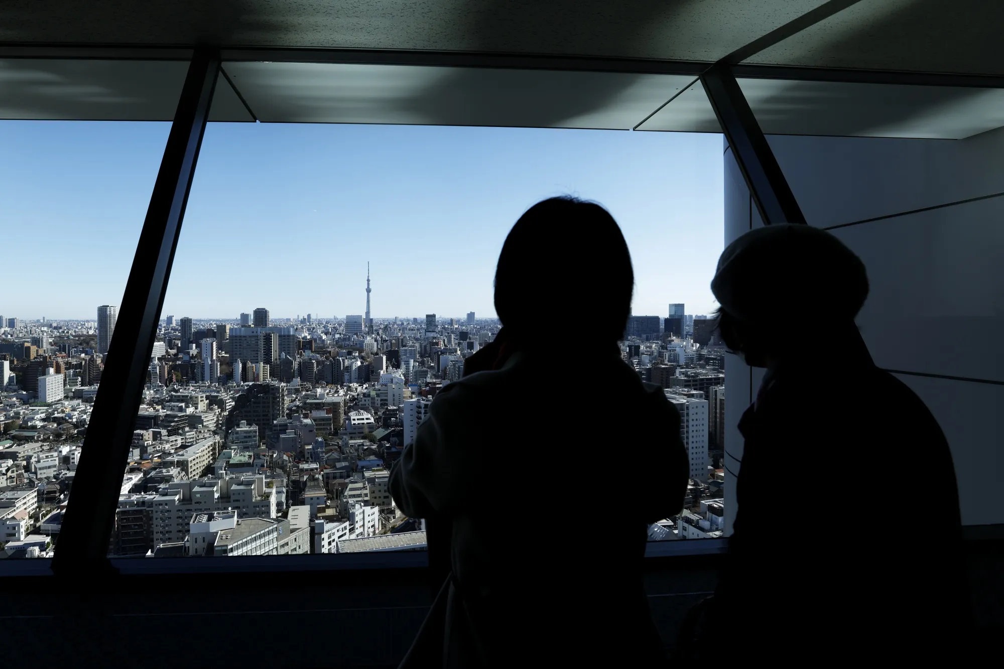 Visitors look out from the Bunkyo Civic Center observation lounge in Tokyo, Japan.