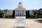 A sign about saving water is posted on browning grass outside the state Capitol in Sacramento, Calif., on Monday, July 11, 2022. California's water use dropped more than 10% in July compared to two years ago, state officials said Wednesday Sept. 7, 2022. (AP Photo/Rich Pedroncelli, File)
