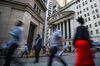 Pedestrians walk along Wall Street near the New York Stock Exchange (NYSE) in New York, U.S..
