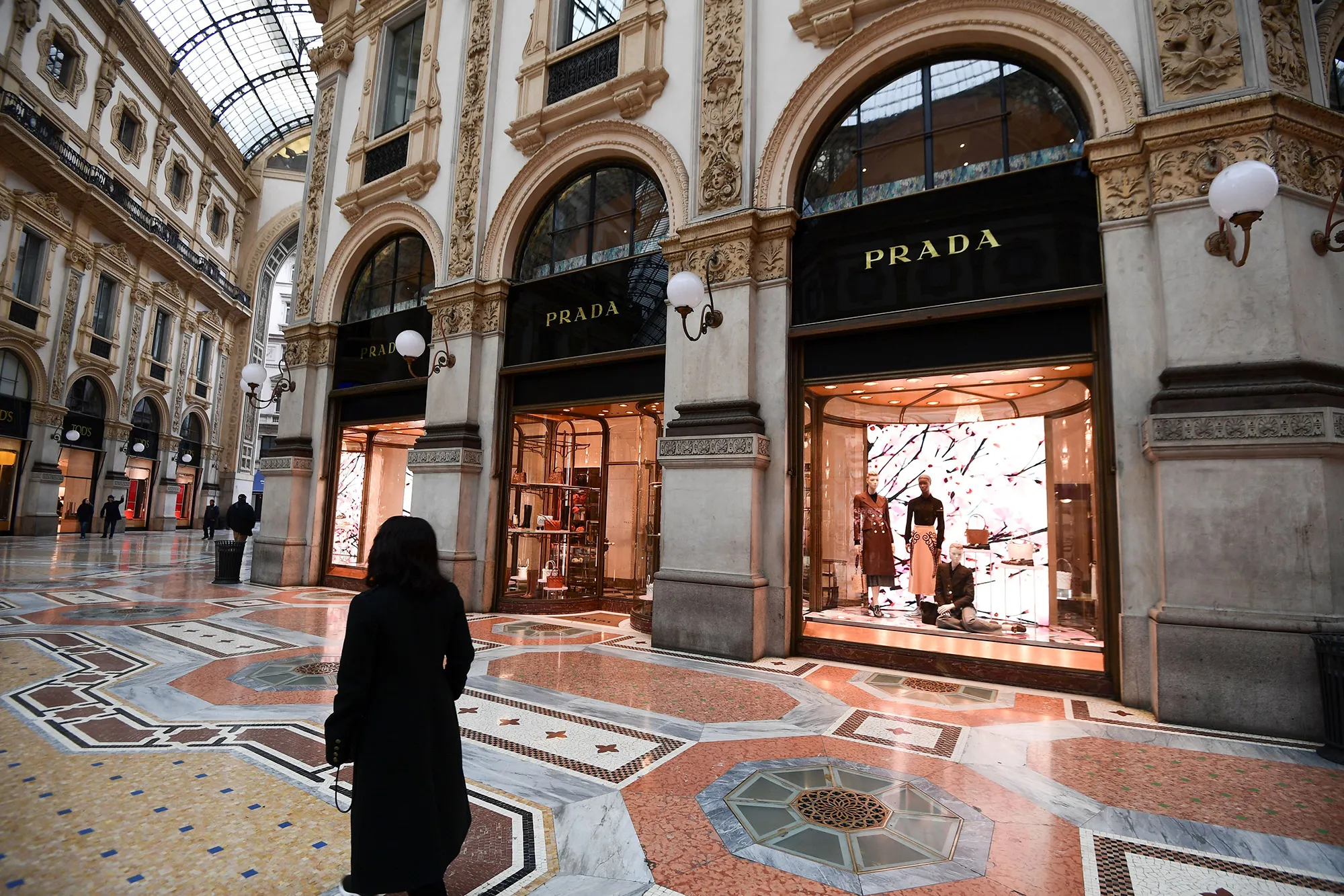 A woman walks by of a luxury shop in a near empty Galleria Vittorio Emanuele II in Milan on Feb. 29.&nbsp;