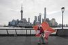 A man carries a kite along the bund as the Lujiazui Financial District stands in the background in Shanghai, China, on Monday, Sept. 4, 2017. The Chinese central bank's tight leash on liquidity is straining the bond market, with the benchmark sovereign yield climbing to near the highest level since April 2015.