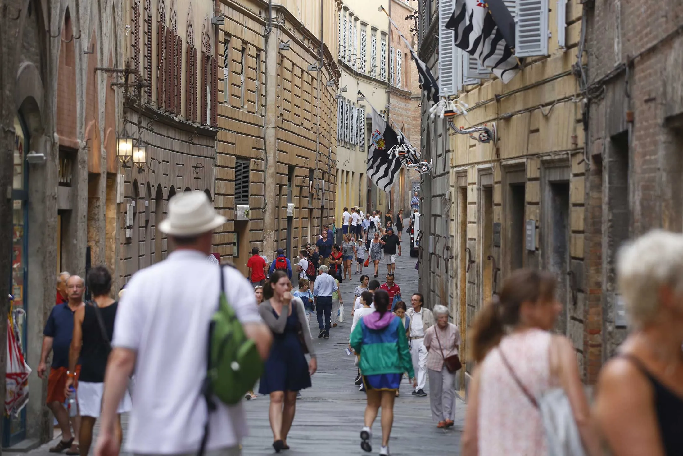 Pedestrians walk along Via Montanini in Siena, Italy, on Friday, Aug. 5, 2016. 
