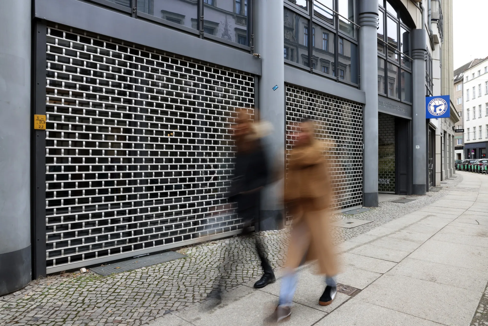 Pedestrians pass a closed store in Berlin.