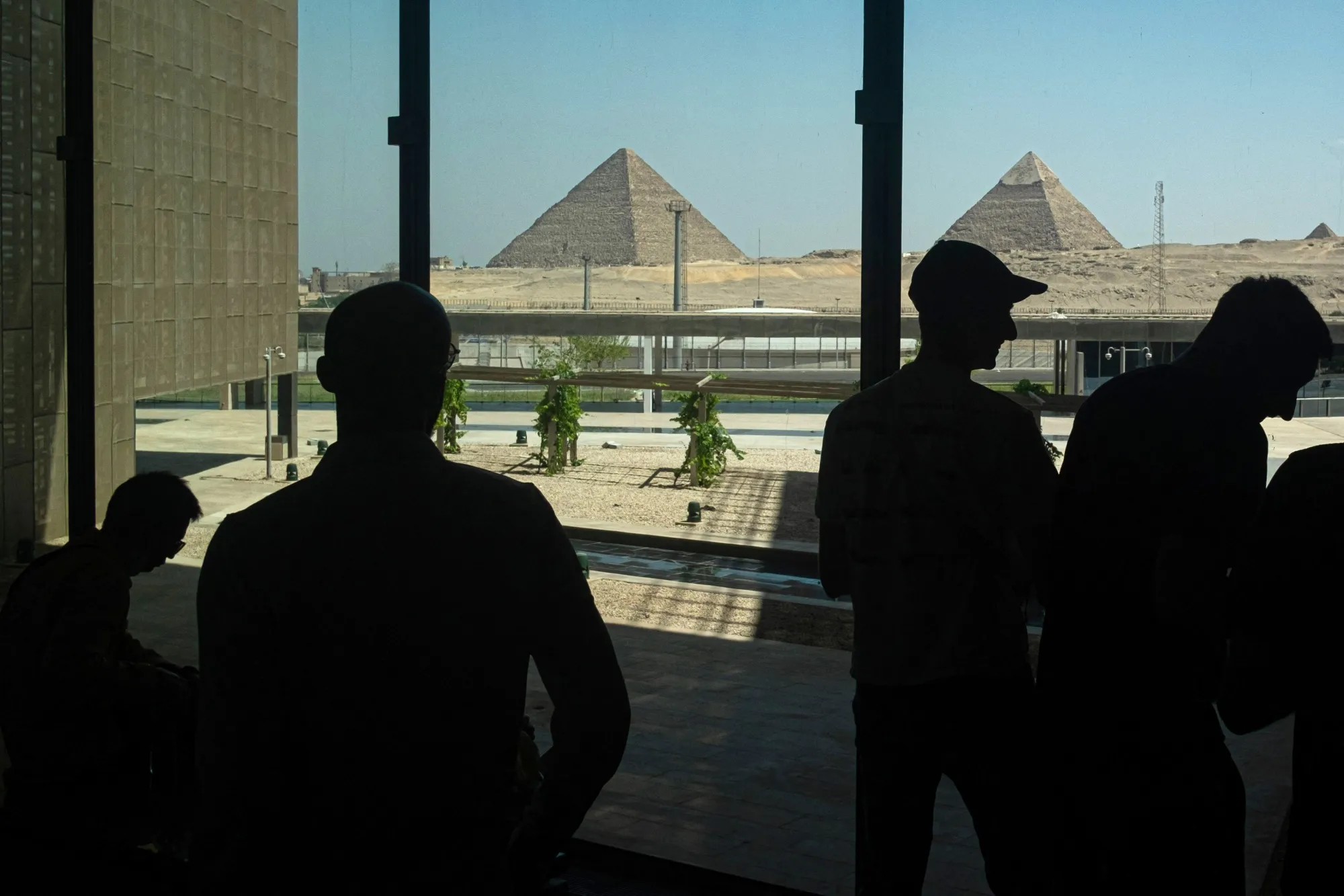 Visitors look out towards the Giza pyramids from the Grand Egyptian Museum.