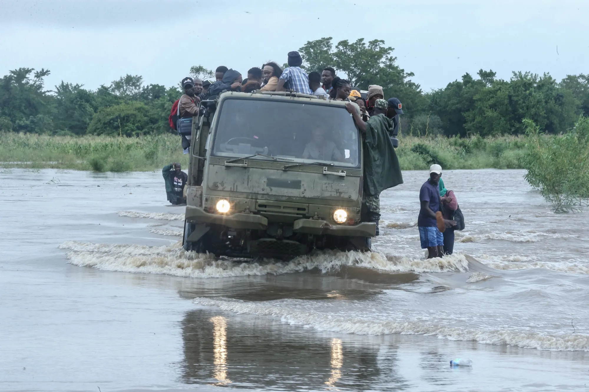 Residents sit on a Mozambique military truck transporting them across floodwater on Jan. 16.