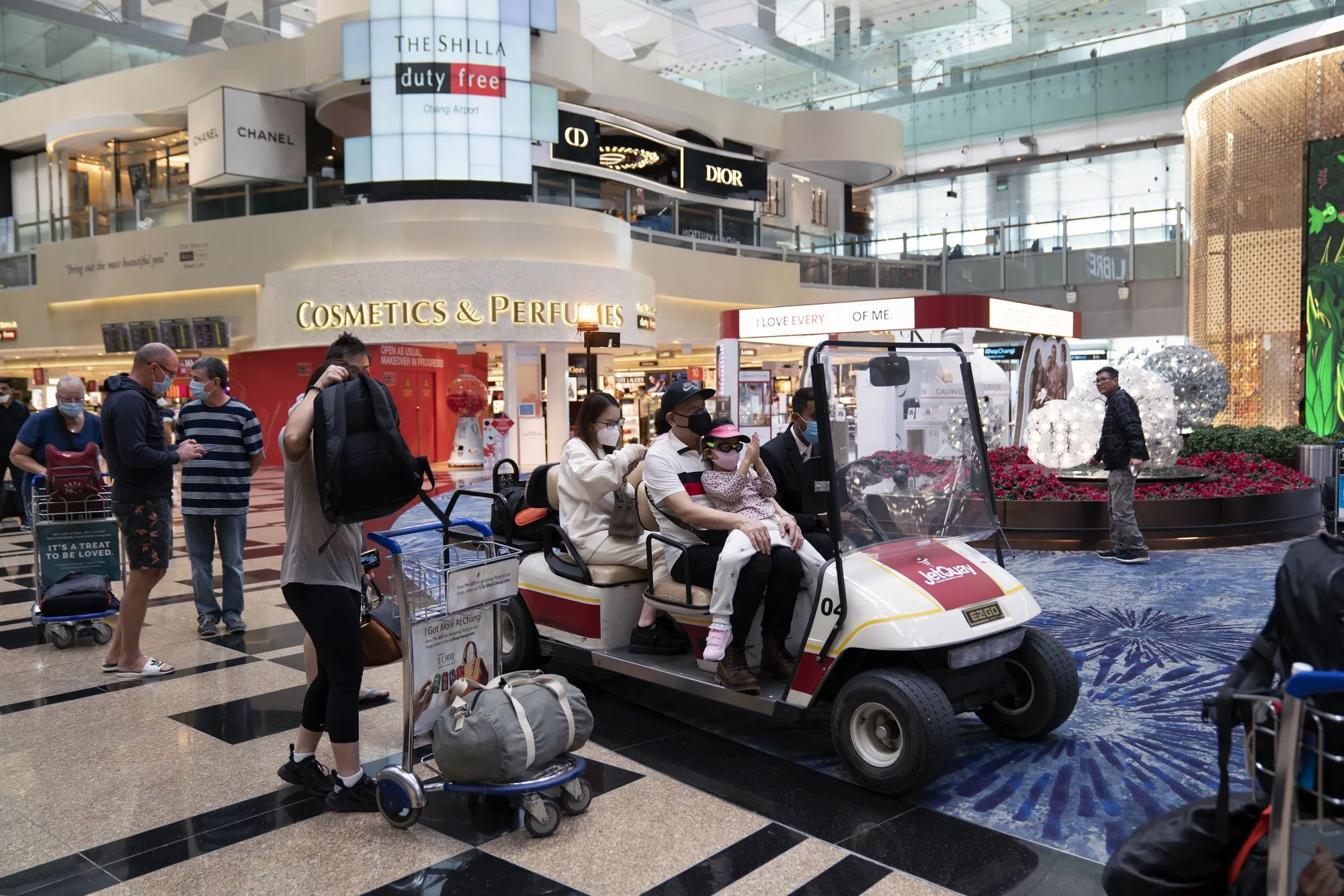 Travelers wearing&nbsp;pass through a transit area in Terminal 3 at Singapore Changi Airport.
