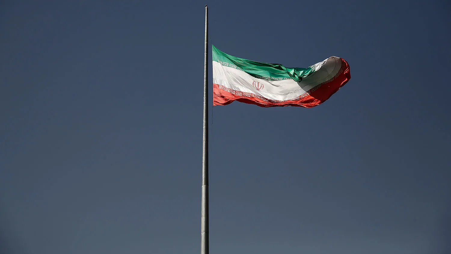 An Iranian national flag flies from a flagpole in a residential district of Tehran on Aug. 24, 2015.
