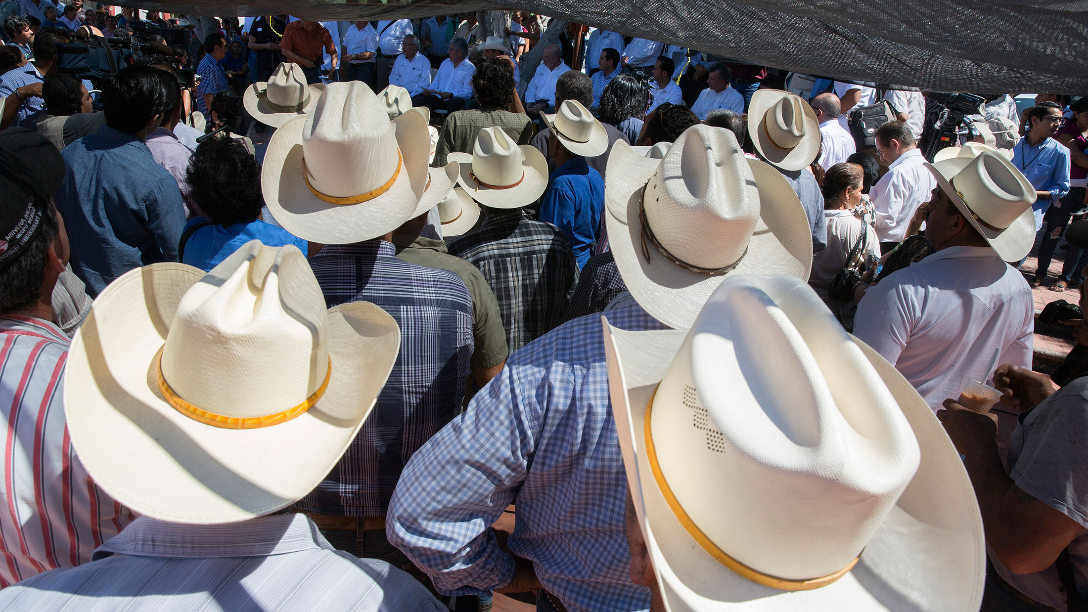 Local farmers and residents gather in the main plaza to listen to government officials speak about compensation for damage from a mine spill in Baviacora, Mexico.
