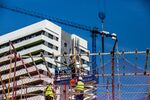 Construction workers labour on a building site in Hospitalet de Llobregat, Barcelona, Spain, on Tuesday, June 4, 2019. After seeing housing costs jump by more than 50% in the past five years, officials in Barcelona are moving to introduce Spain's most aggressive rent controls.