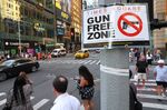 People walk past a &quot;Gun Free Zone&quot; sign posted in Times Square, New York.