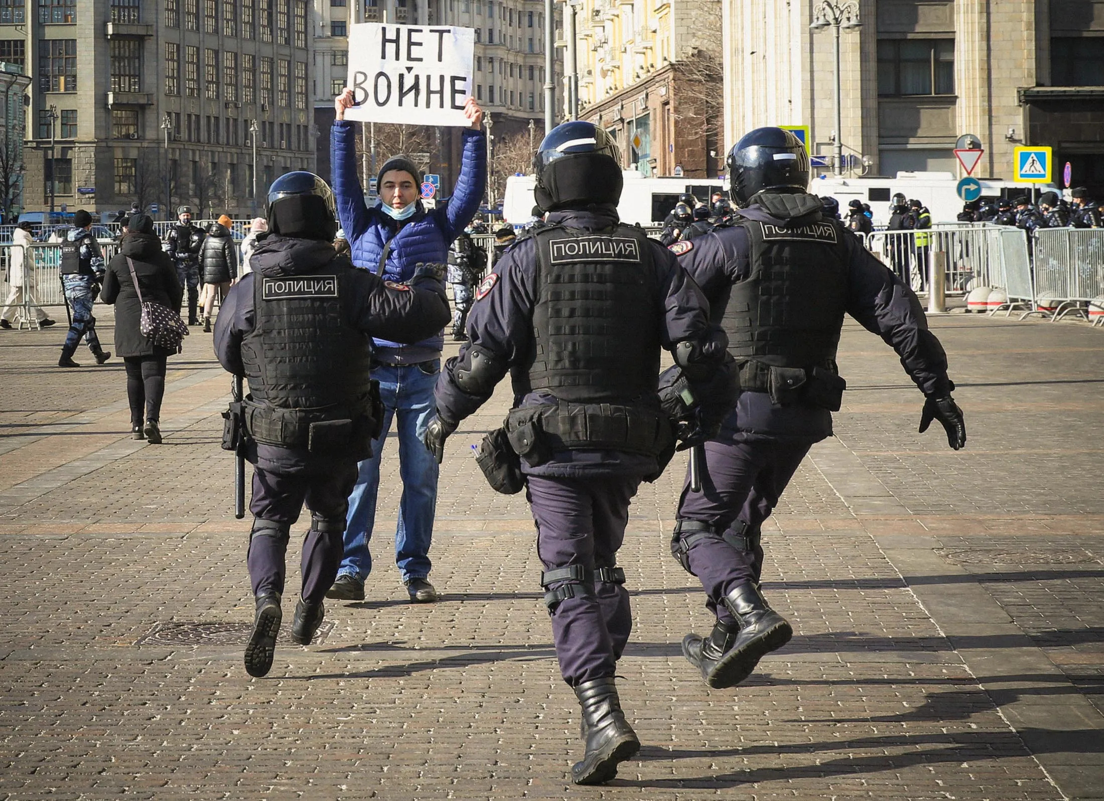 Russian Police officers run to detain a man holding a poster that reads&nbsp;“No to war,”&nbsp;during a protest&nbsp;outside the Kremlin on&nbsp;March 13.