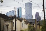 The skyline of downtown Houston looms over homes in the Fifth Ward neighborhood in 2018. 