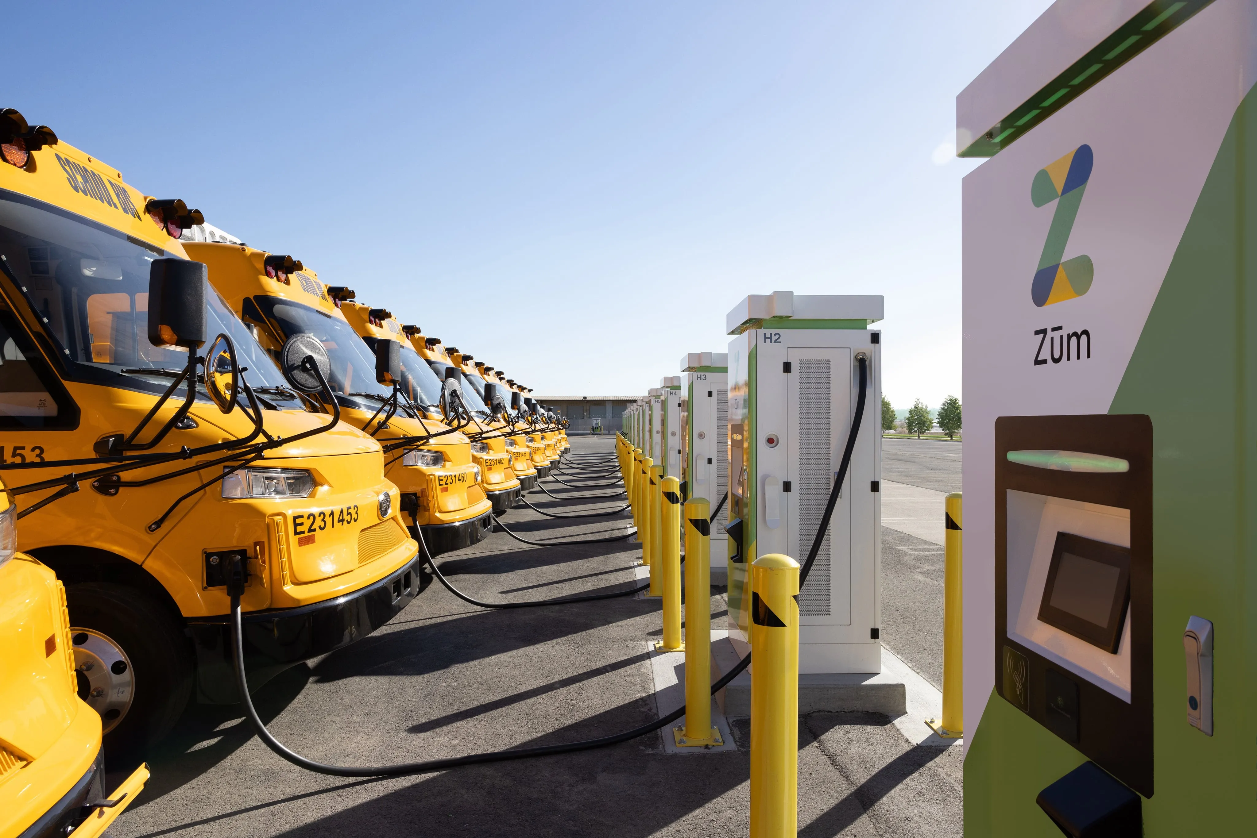 Zūm electric school buses charging at the Oakland Unified School District depot.