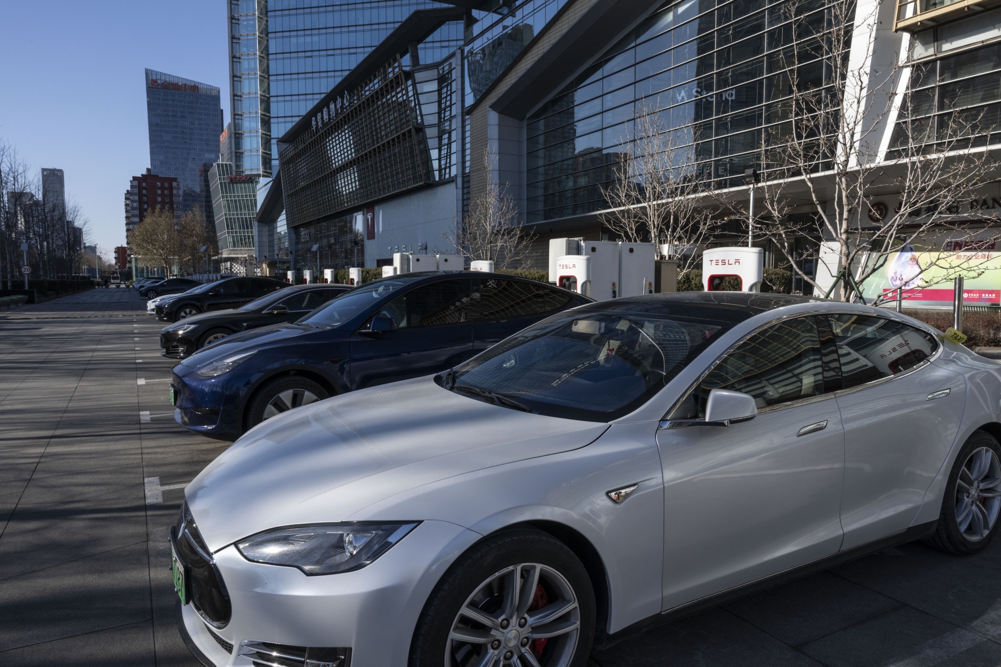 Tesla Inc. electric vehicles parked at charging stations in Beijing.