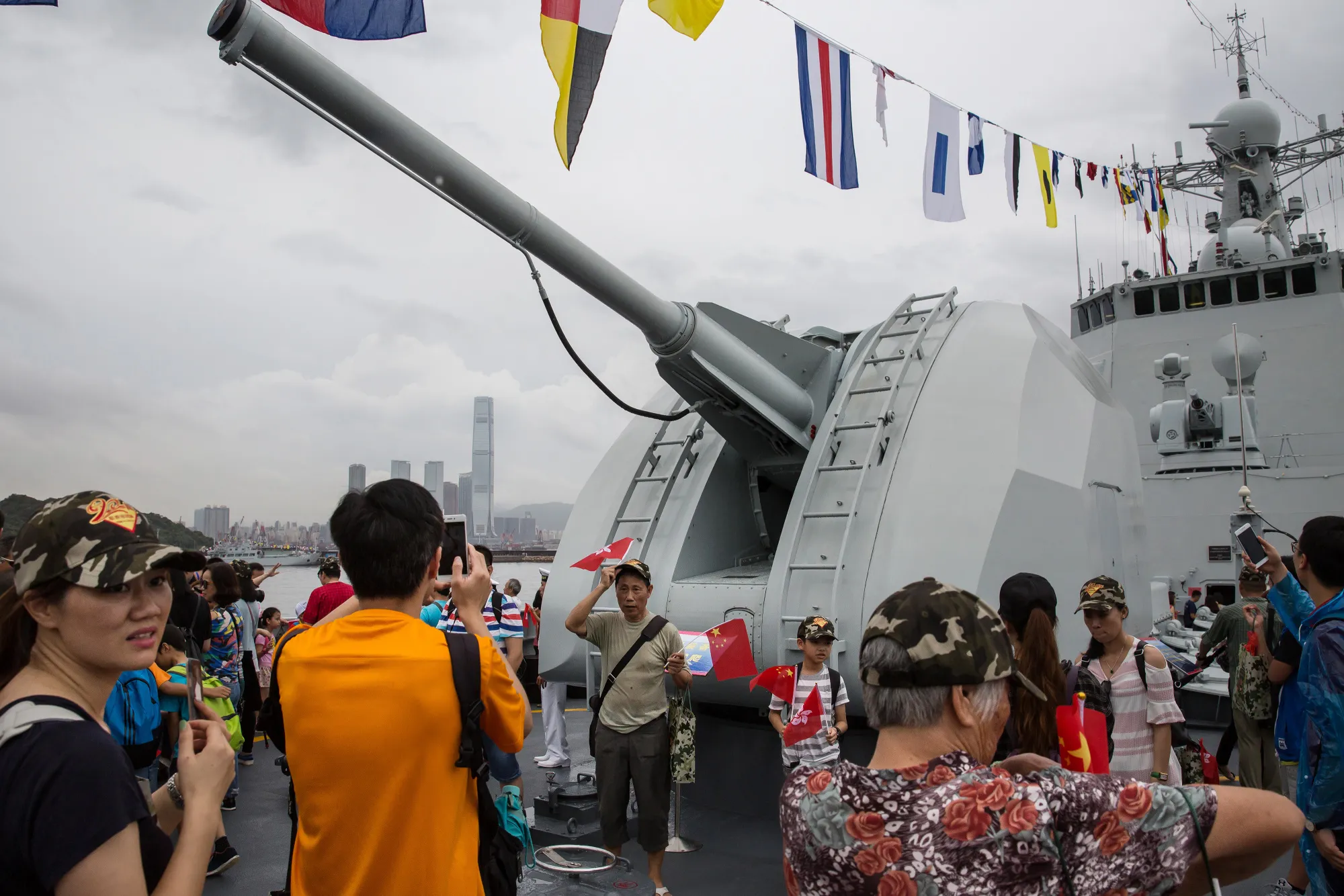 Visitors pose for photographs in front of a weapon on the deck of a People's Liberation Army&nbsp;ship during an open day at the Ngong Suen Chau Barracks in Hong Kong.
