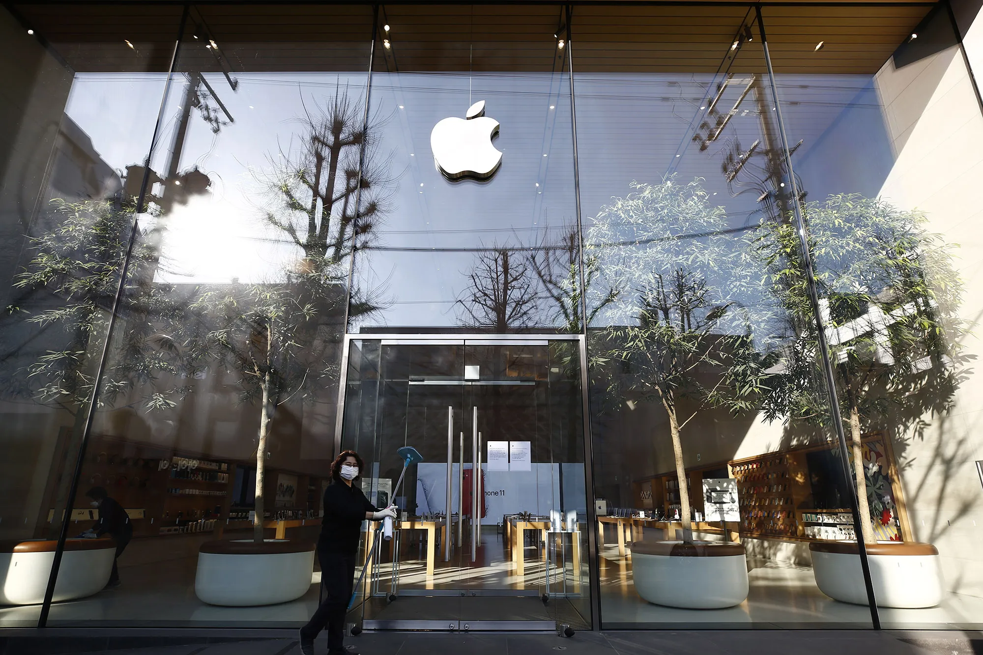 A worker cleans the exterior of the Apple store in Seoul on March 16.
