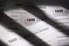 U.S. Department of the Treasury Internal Revenue Service (IRS) 1040 Individual Income Tax forms for the 2017 tax year sit on a table.