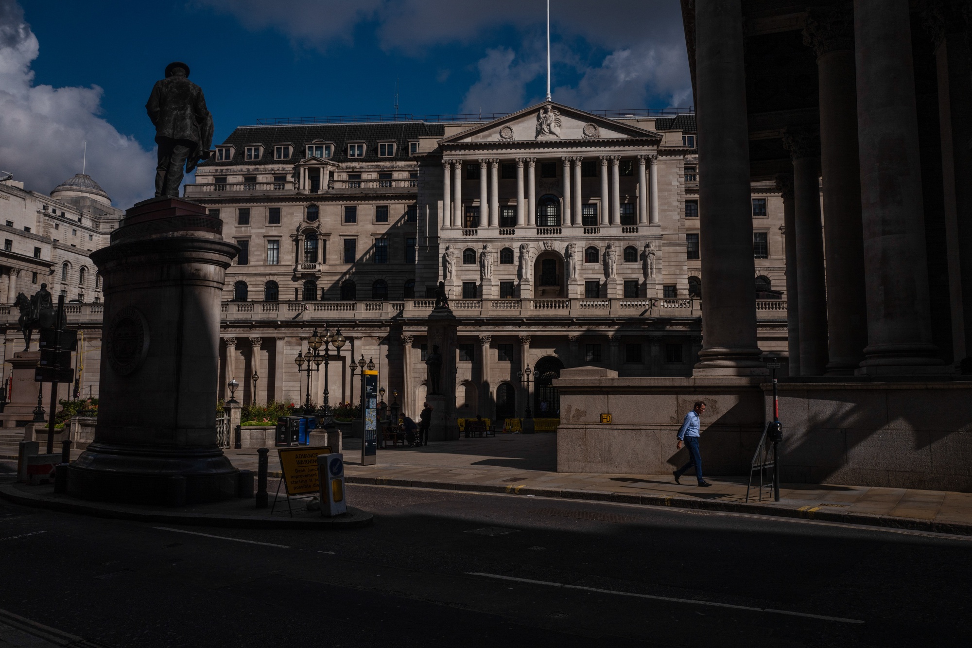 A pedestrian walks past the Bank of England in the City of London.