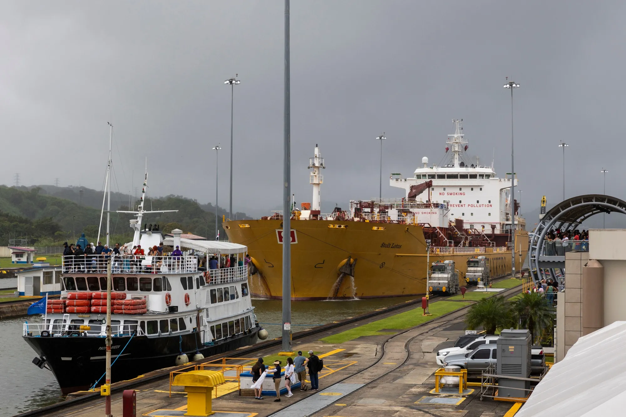 A passenger ship and a tanker ship navigate through the Miraflores locks of the Panama Canal.