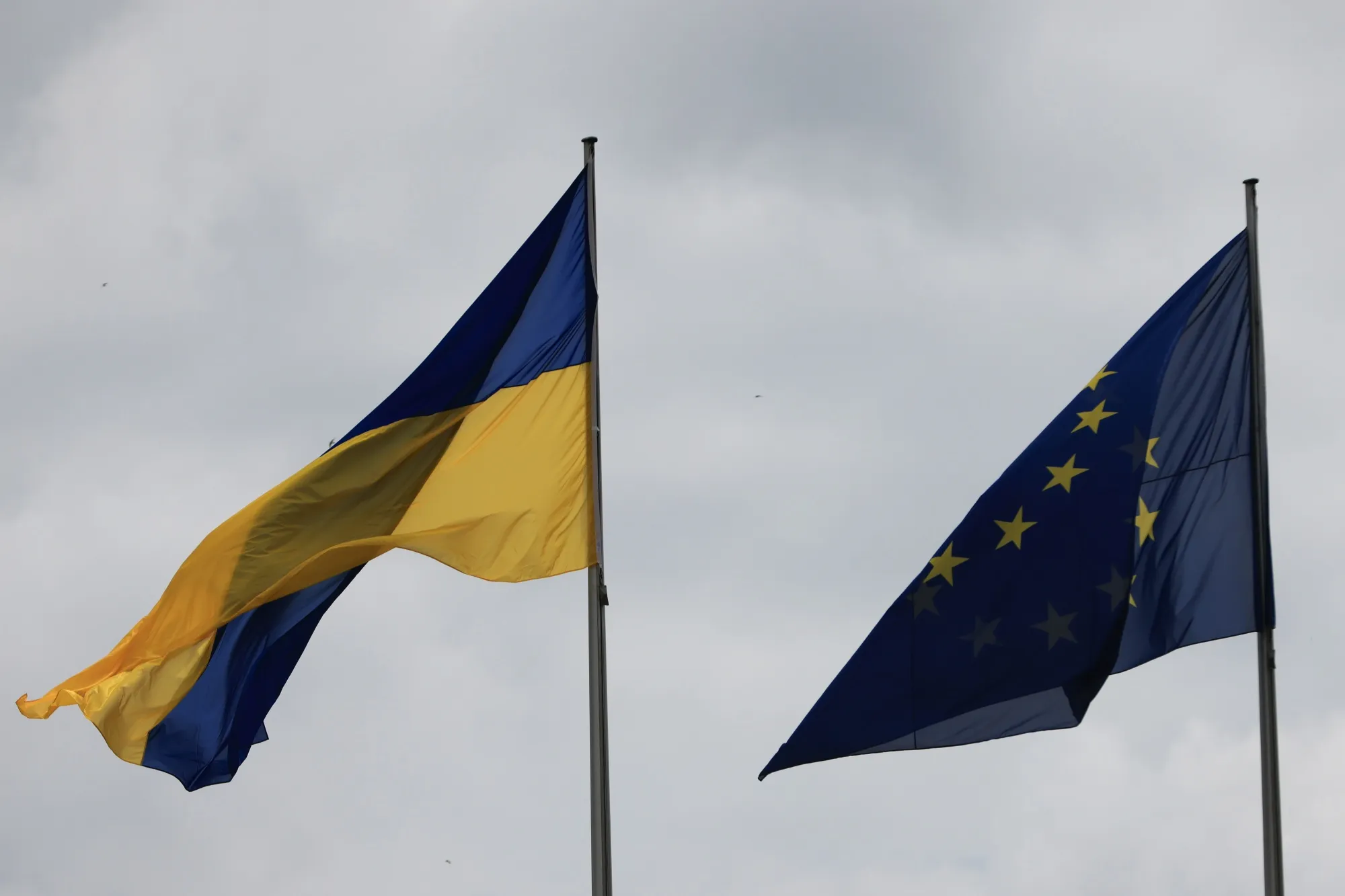 The national flag of Ukraine, left, and the European Union flag.