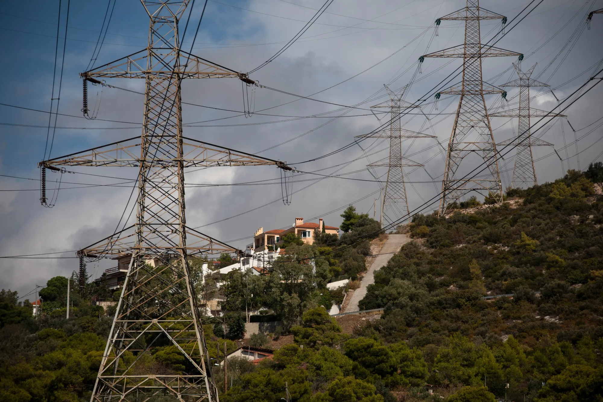 Electricity transmission pylons near residential homes northeast of Athens, Greece.