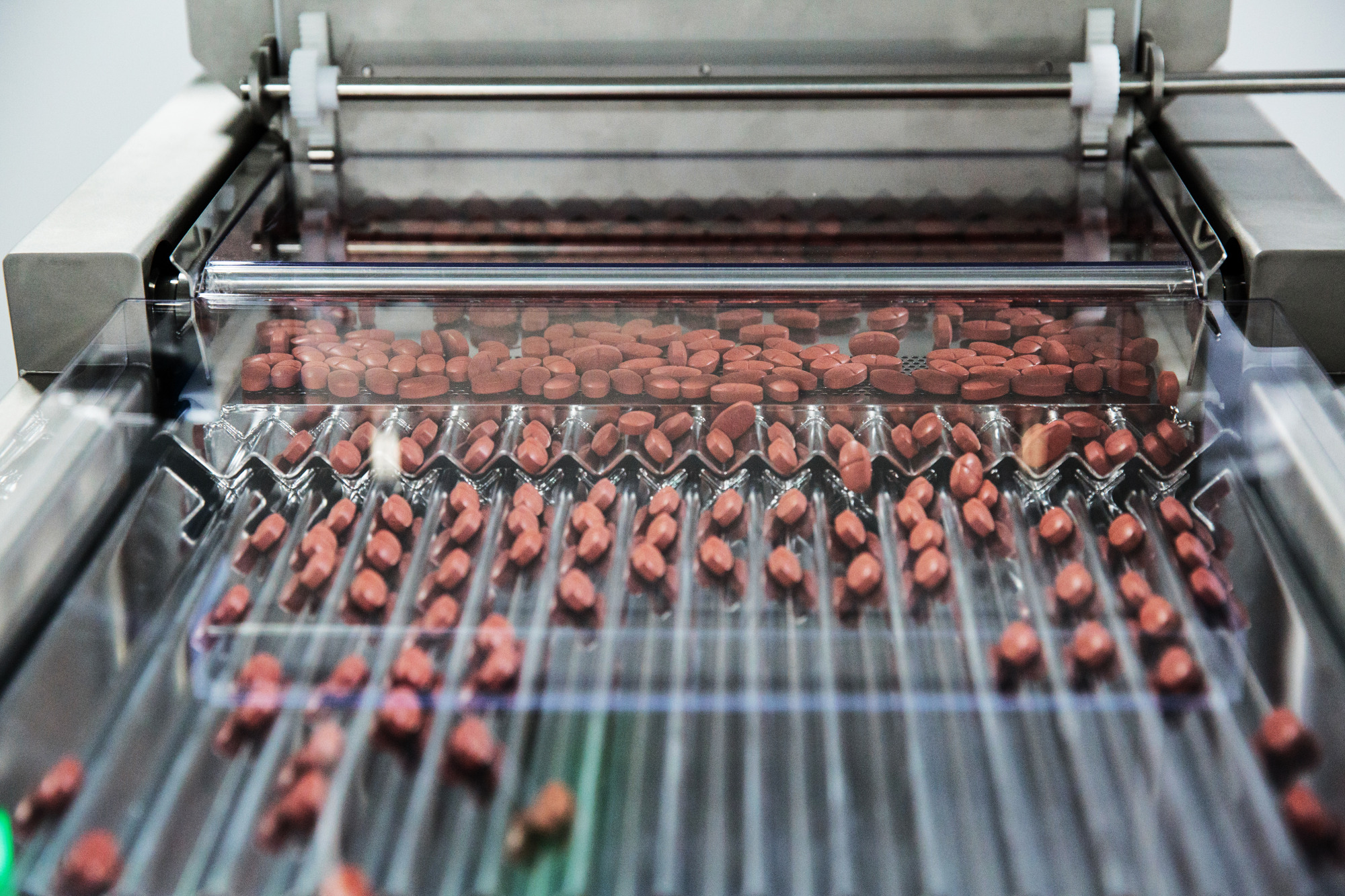 Metformin pills move through a sorting machine at a pharmaceutical plant in India.