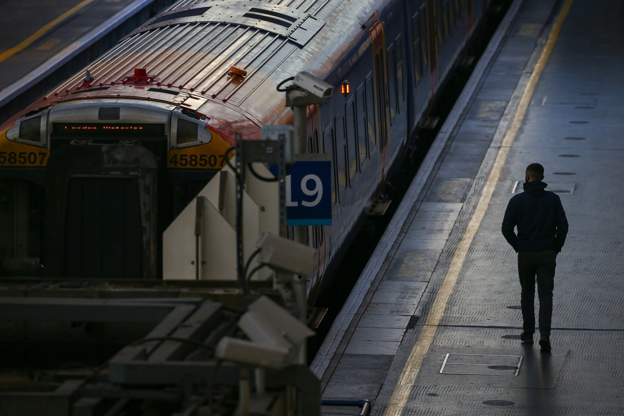 A commuters stands on a platform at London Waterloo railway station in London, U.K.