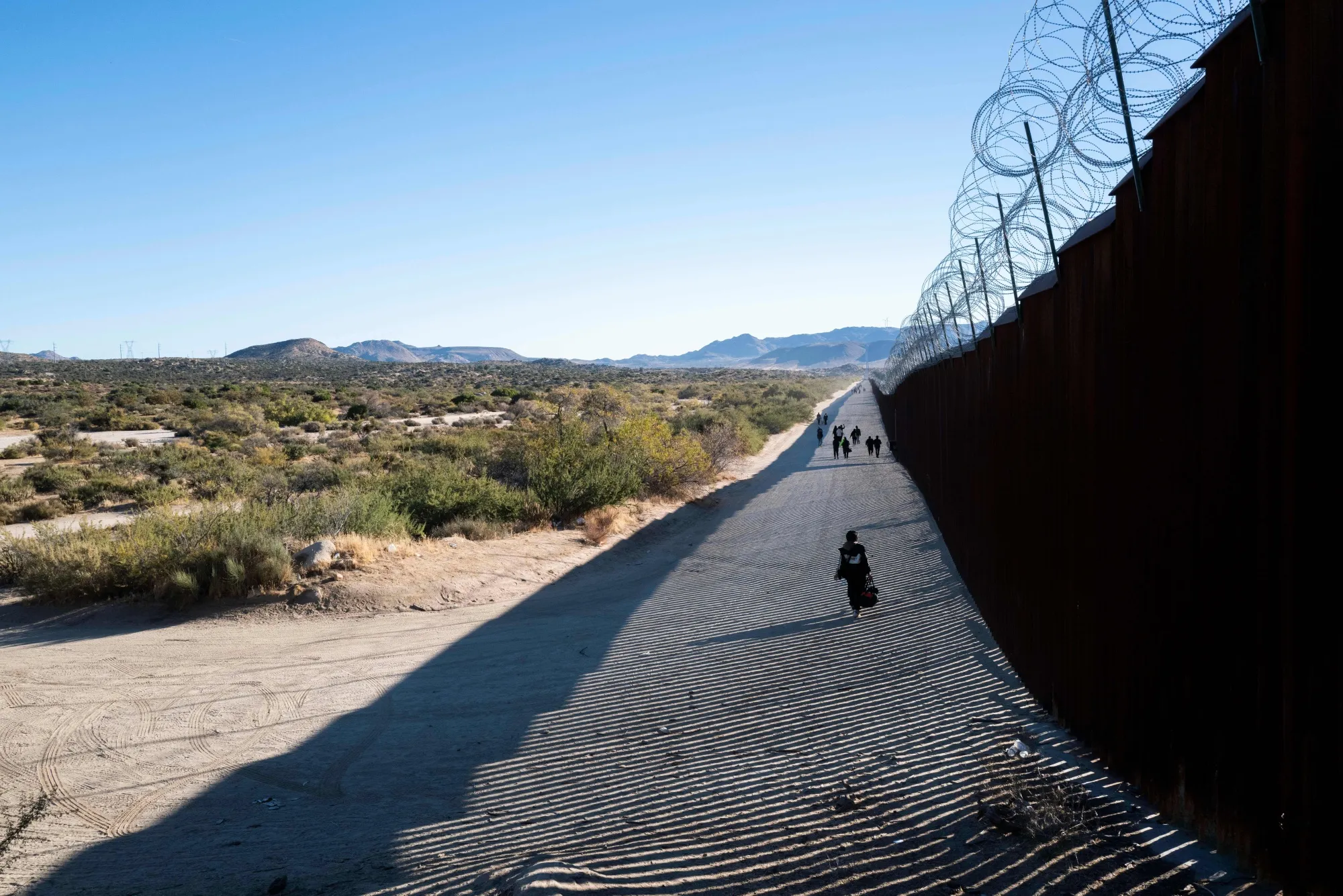 Migrants after entering the United States through a gap in the border wall in Jacumba Hot Springs, California.