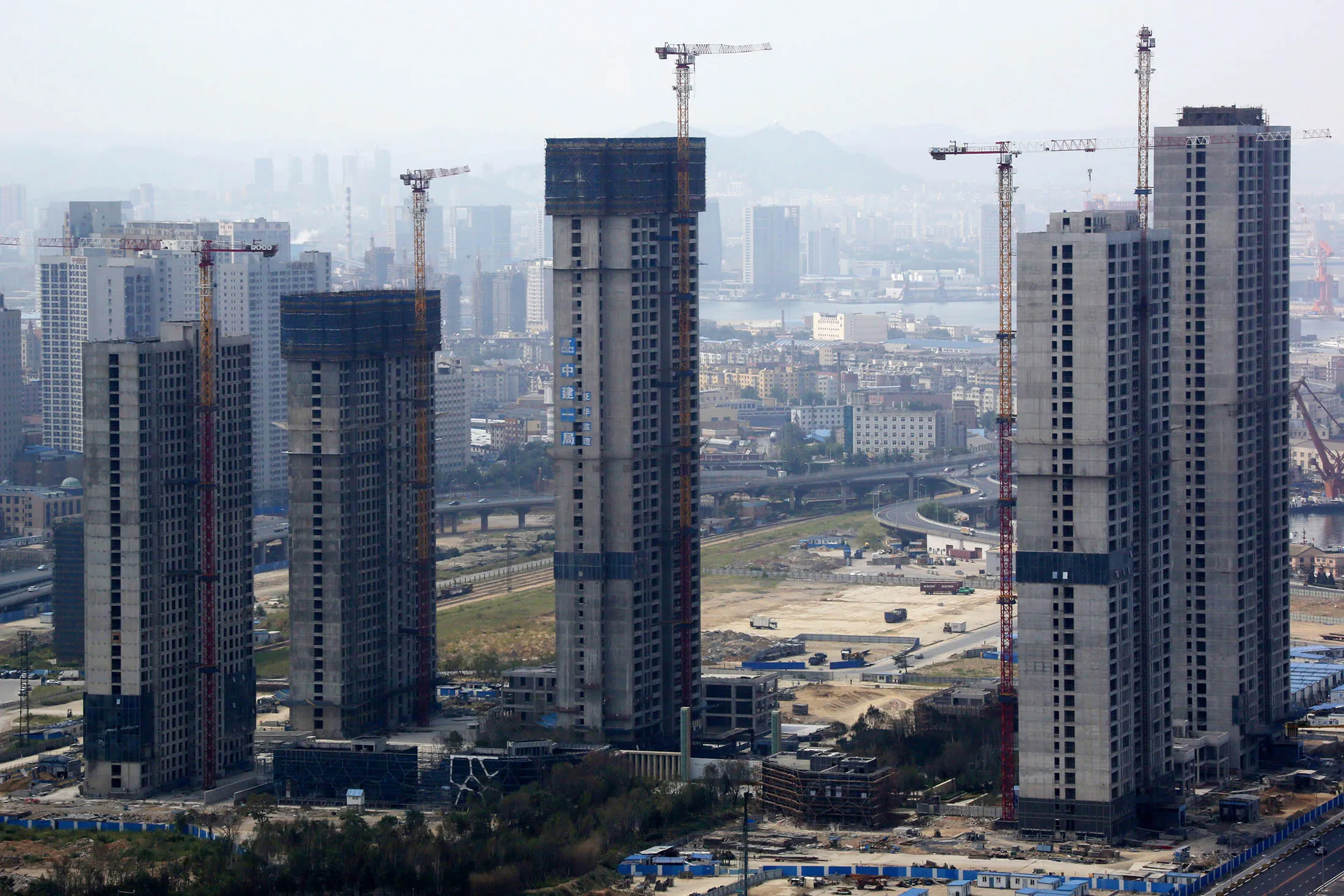 Buildings are under construction, seen from a building at the Dalian Wanda Center, a property owned by Dalian Wanda Group, in Dalian, China, on Friday, Sept. 13, 2013. Goldman Sachs Group Inc. this month raised its estimate for China's economic growth for the third and fourth quarters, citing improving global demand and a stronger-than-expected domestic industrial recovery.
